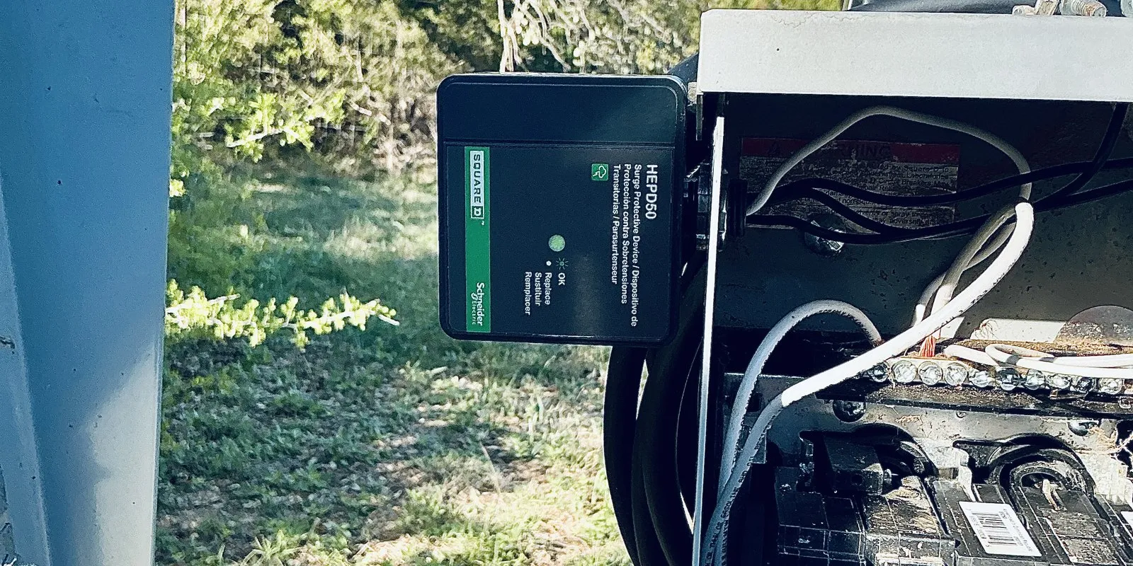 A Square D whole-house surge protective device installed beside an outdoor electrical panel in Austin.